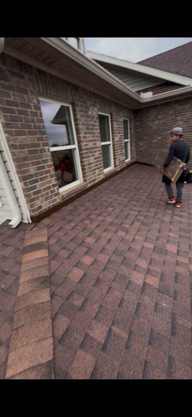 Shingles meeting a brick wall on a Wicksburg job Burgundy shingles stepping up beside a brick wall on a MAC Construction job in Wicksburg, AL