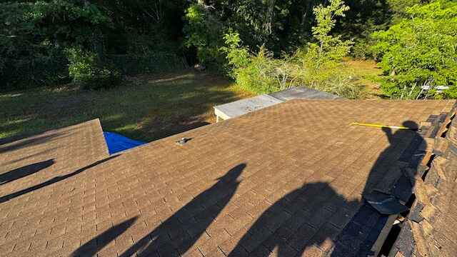 Older brown shingle roof in Dothan Older weathered brown shingle roof with a blue tarp at the edge, MAC Construction job in Dothan, AL